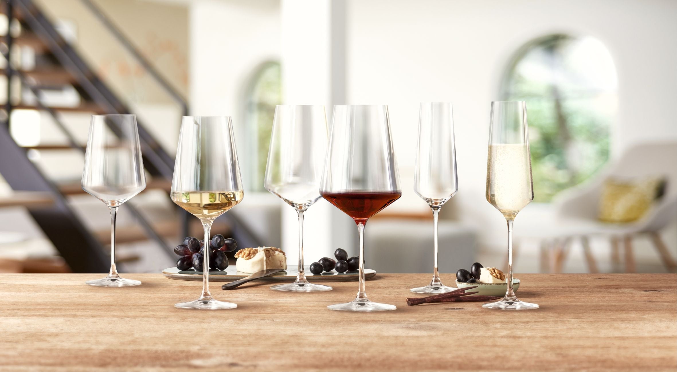 Weinglas mit Gravur auf einem Tisch die mit Rotwein und Weißwein gefüllt sind. Alle Weingläser gibt es hier mit Gravur