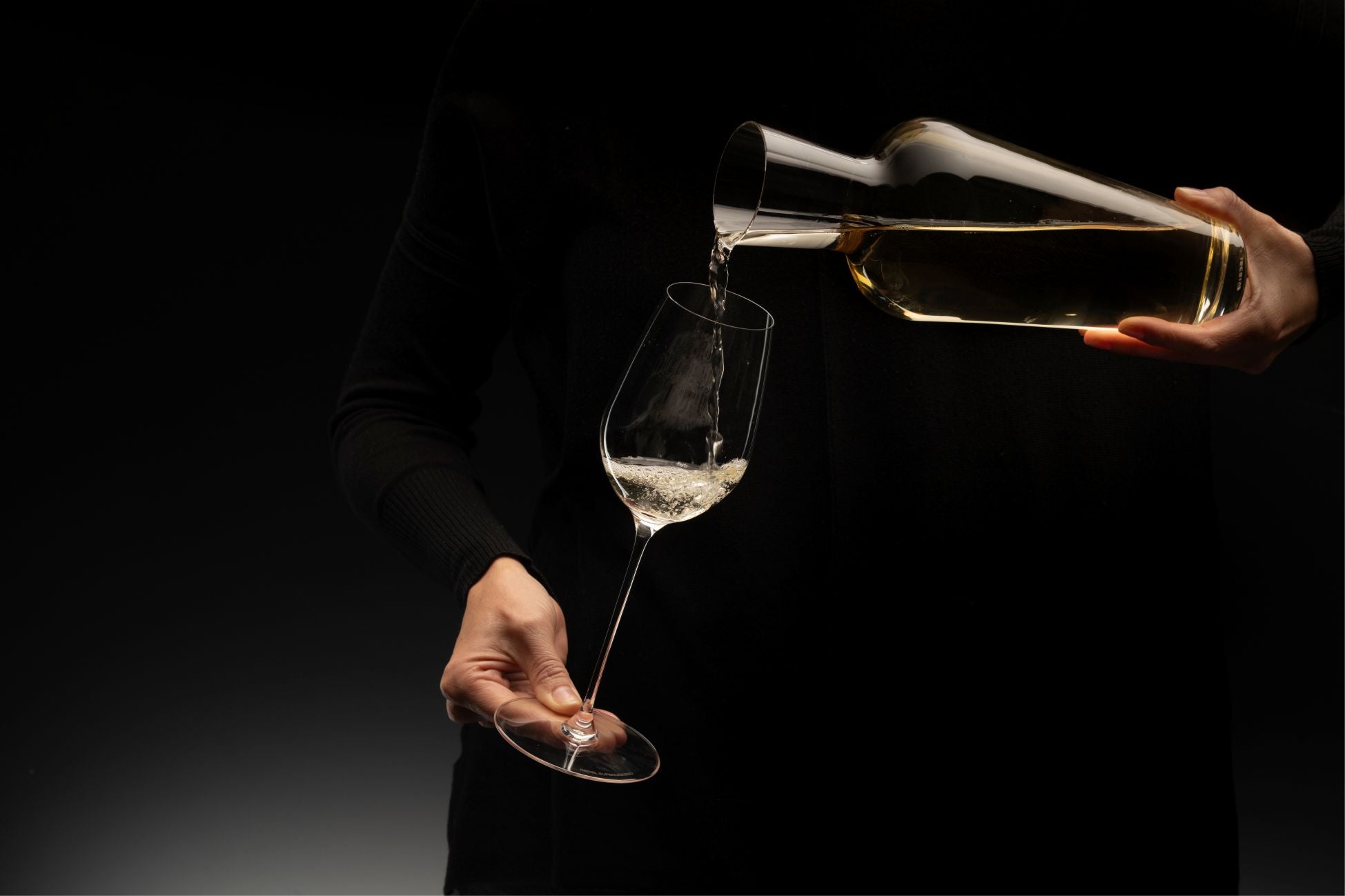 Ein Riedel Weinglas mit Gravur wird dekantiert